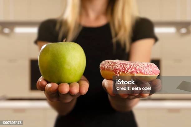 Choosing Between Donut And Apple Stock Photo - Download Image Now - Healthy Eating, Food, Unhealthy Eating