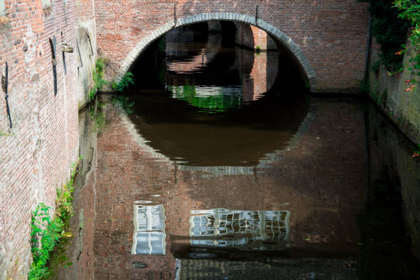 istock canal with brick wall, reflection in Den Bosch, 's Hertogenbosch, The Netherlands 1007311526