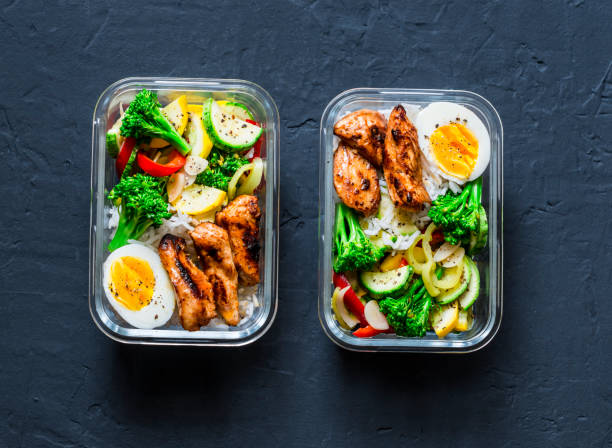 ris, stekta grönsaker, ägg, teriyaki kyckling - hälsosam balanserad lunchbox på en mörk bakgrund, ovanifrån. hem mat för office koncept - matlåda bildbanksfoton och bilder