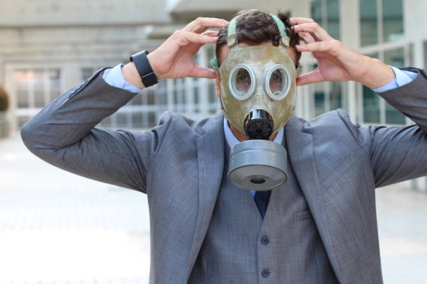 istock Businessman wearing gas mask in office space 1007324930