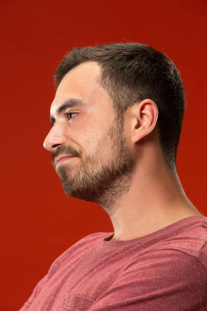 istock Beautiful bored man bored isolated on red background 1007331146