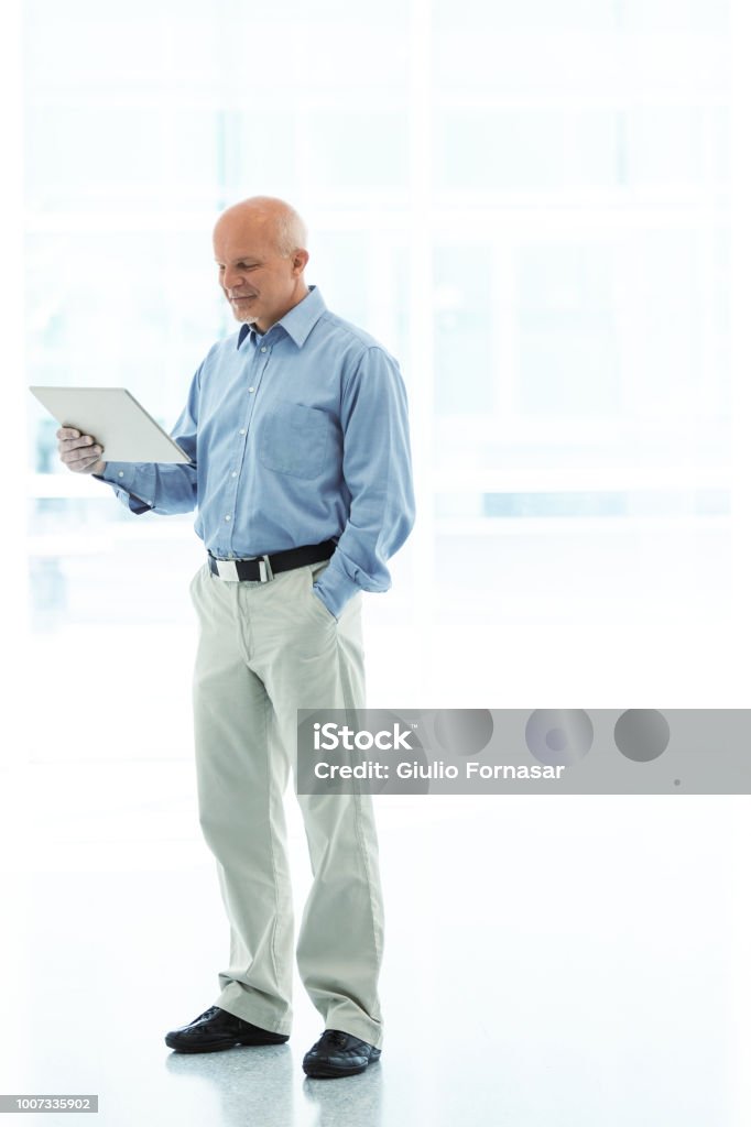 While Viewing Man Standing While Viewing Tablet Stock Photo - Download Image Now ...
