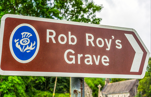 Balquhidder, Scotland - A sign in the Trossachs region of Scotland directing visitors towards the burial site of the 17th Century Scottish Hero, Robert Roy MacGregor.