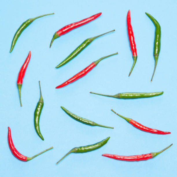 istock Food flatlay pattern of chili peppers on blue background 1007342282