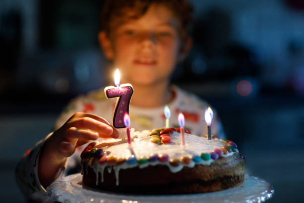 adorável loira garoto menino feliz comemorando seu 7 aniversário. - birthday cake family germany indoors - fotografias e filmes do acervo