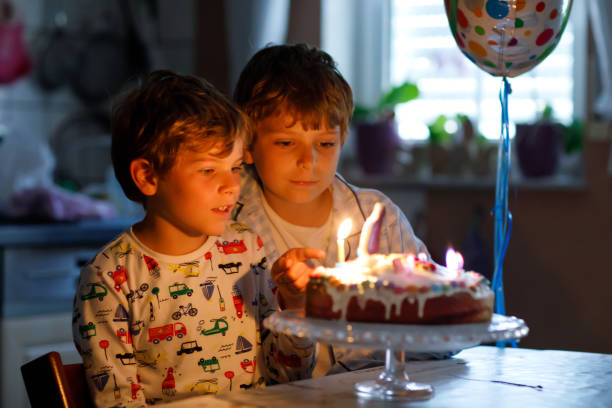 duas belas crianças, meninos pré-escola comemorando aniversário e velas - birthday cake family germany indoors - fotografias e filmes do acervo