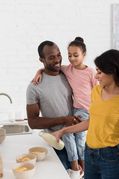 istock young family pouring milk into cereal breakfast at kitchen 1007345620