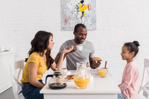 istock beautiful young family having breakfast on kitchen together 1007345654
