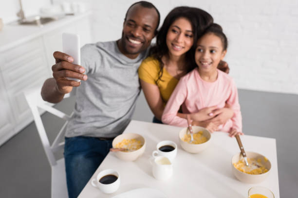 istock smiling young family taking selfie on kitchen while having breakfast 1007345688