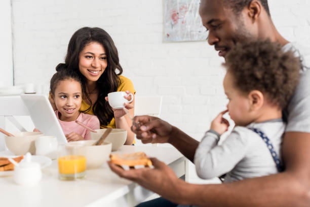 istock father applying peanut butter on toast for son at kitchen 1007345704