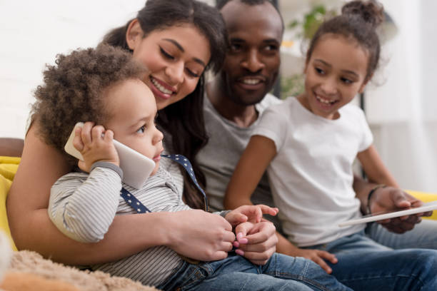 istock happy young family spending time together with devices 1007345756