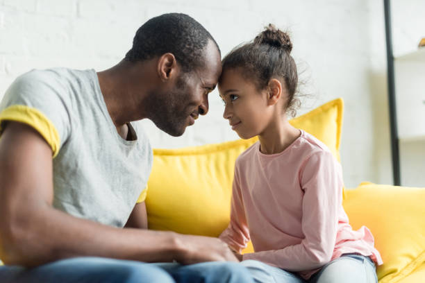istock father and daughter looking at each other and touching with foreheads 1007354526