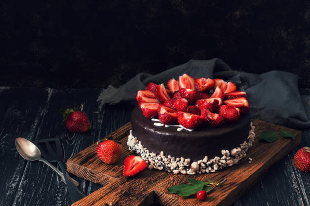 istock Chocolate cake with fresh strawberries on a dark background. Selective focus. Food mood 1007354742