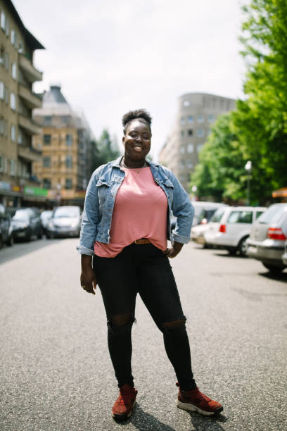 istock Young woman standing on road and smiling 1007367146
