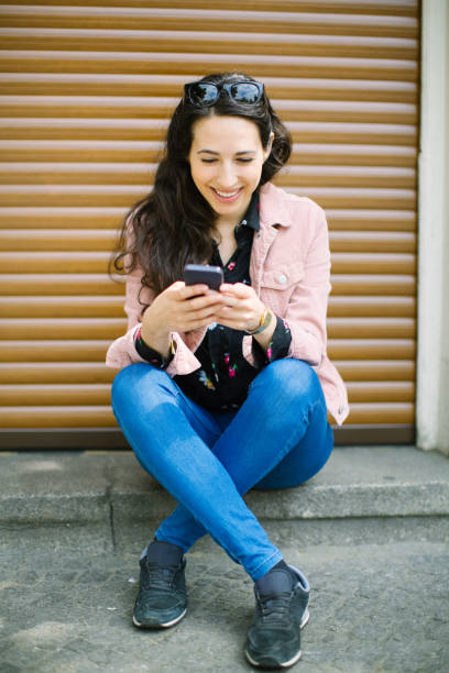 istock Woman using phone on the sidewalk 1007370170