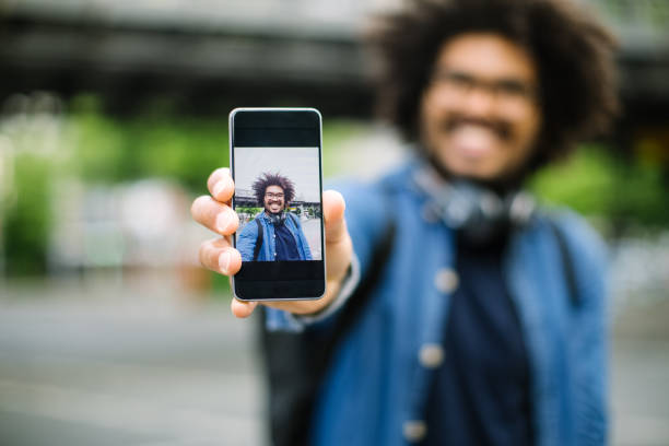 hipster mostrando su selfie - dispositivo de pantalla fotos fotografías e imágenes de stock
