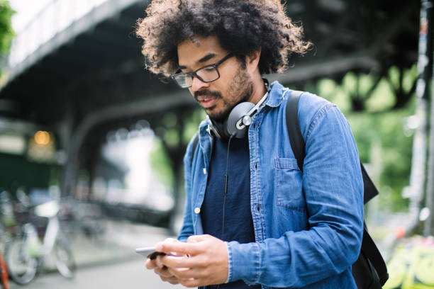 istock urban man walking down the street using mobile phone 1007370666