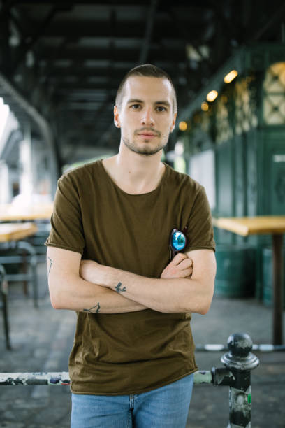 Handsome man in casuals standing by a railing outdoors
