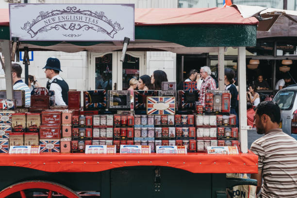 vielzahl von tees über verkauf einen marktstand in portobello road market, notting hill, london verkäufer sitzt neben ihm, menschen zu fuß auf den hintergrund. - english breakfast tea stock-fotos und bilder