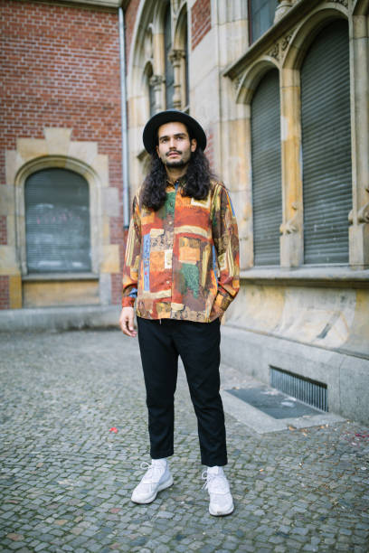 Full length portrait of young man in casual outfit looking at camera. Man standing outdoors in casual wear.