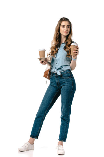 istock beautiful student holding coffee in paper cups isolated on white 1007387996