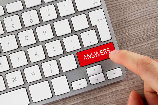 Index finger is pushing 'Answers' button on computer keyboard