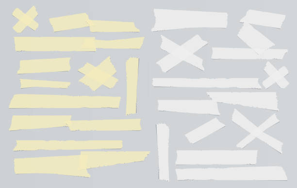 istock White and yellow adhesive, sticky, masking, duct tape, paper strips pieces for text on gray background 1007394662