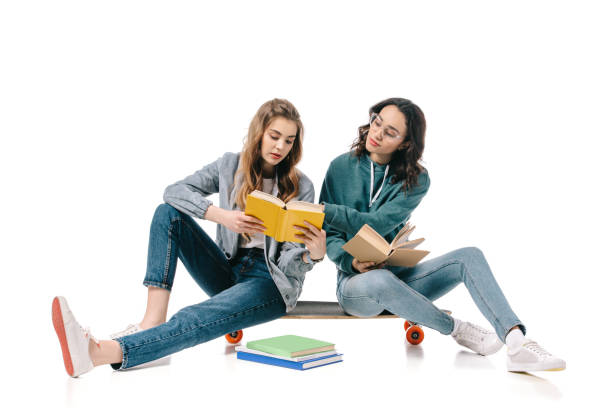 istock multicultural students sitting on skate with books isolated on white 1007395626
