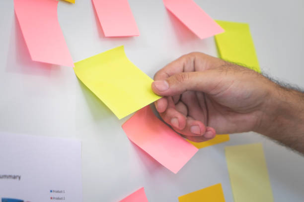 istock Hand pulling reminder posted note paper out of the board 1007400764