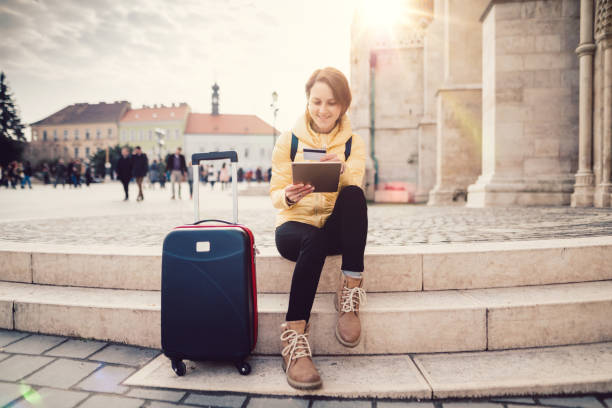 Woman traveling in Europe and using credit card for hotel reservation Young woman in Budapest making credit card payments from tablet fishermens bastion photos stock pictures, royalty-free photos & images