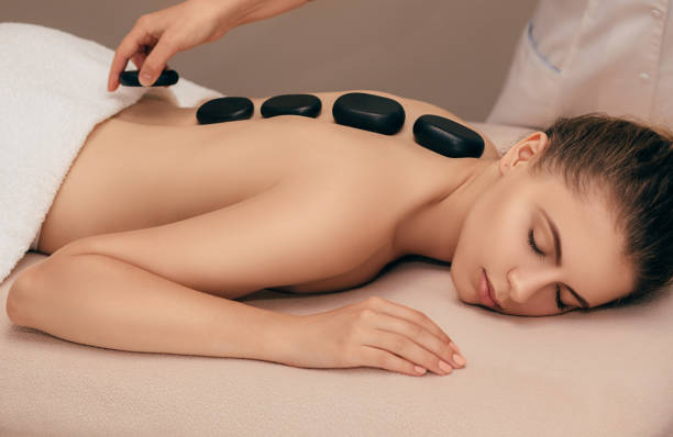 istock woman getting hot stone massage treatment 1007419954