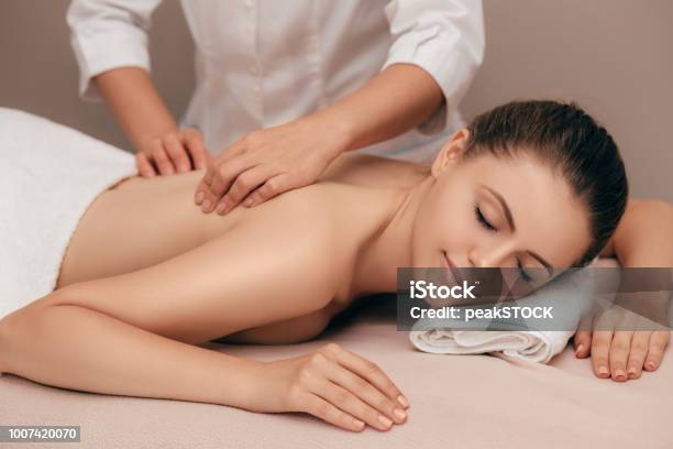 Giovane Donna Che Riceve Un Massaggio Al Salone Spa - Fotografie stock e altre immagini di Massaggiare