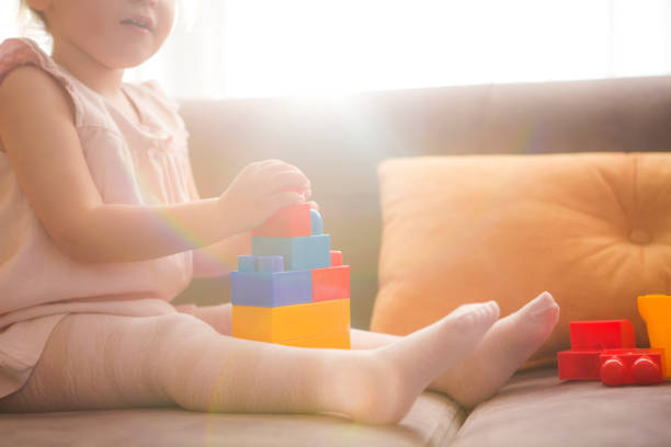 istock Little girl playing with toy blocks 1007422678