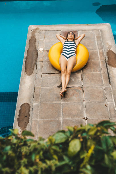 istock Woman with yellow inflatable ring in swimming pool 1007425476