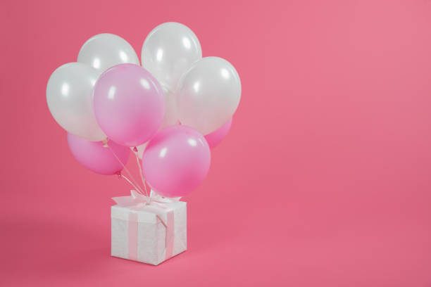 istock Gift box and balloons on pink background 1007425590