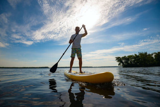 istock Joyful man paddling on a SUP board 1007425810