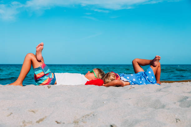 istock little boy and girl relax on tropical beach 1007438576