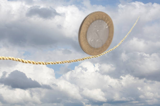 istock Ten Indian Rupees Coin balancing on golden rope 1007441172