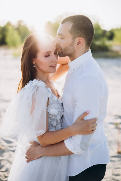istock beautiful happy couple embracing on beach with back light 1007441364