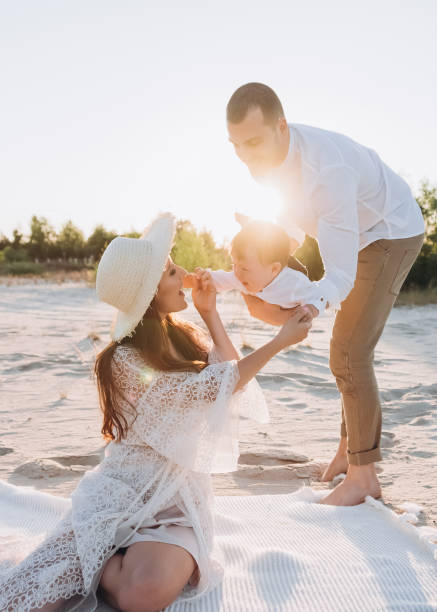 istock happy family with baby having fun on beach with sunlight 1007441454