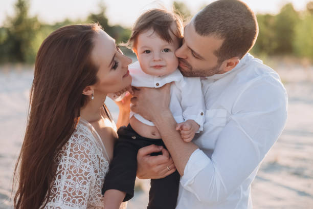 istock happy mother and father hugging little son on beach 1007441490