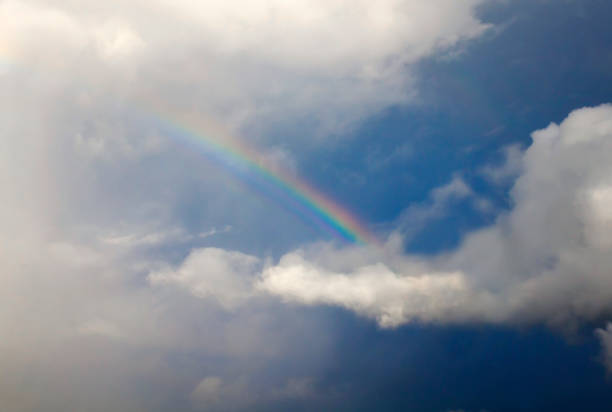 istock natural background with a bright multicolored rainbow among white fluffy clouds against a blue sky after a rain in summer 1007445246