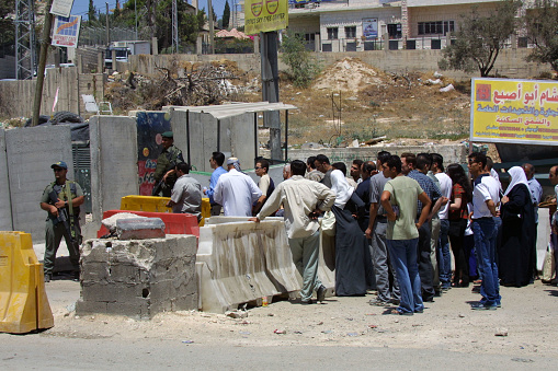 Jerusalem, Israel - Aug. 9, 2002:  Palestinians wait at a checkpoint to enter the city from the West Bank.