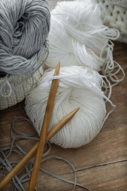istock A woven basket with white and gray thread for knitting and knitting needles. White sweaters and yarn for knitting closeup. Winter 1007461970
