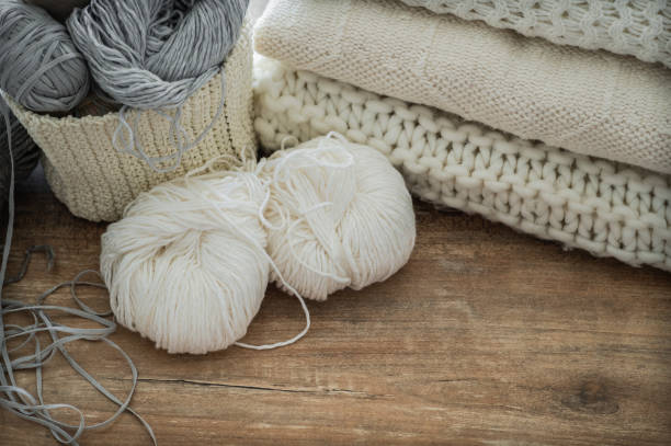 istock A woven basket with white and gray thread for knitting and knitting needles. White sweaters and yarn for knitting closeup. Winter 1007462004