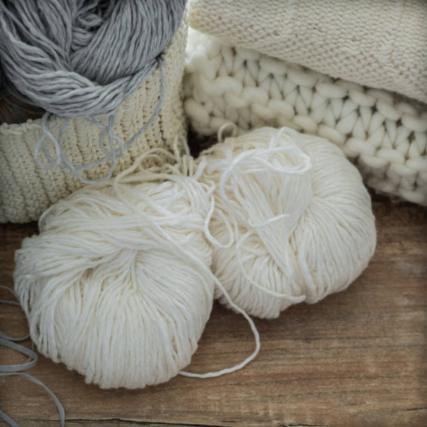 istock A woven basket with white and gray thread for knitting and knitting needles. White sweaters and yarn for knitting closeup. Winter 1007462028