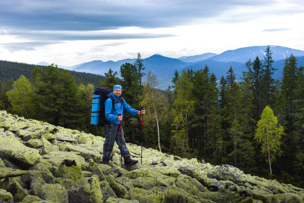 istock A backpacker in blue standing on the stone slope 1007477282