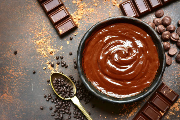 istock Chocolate ganache in a black bowl with ingredients for making 1007485060