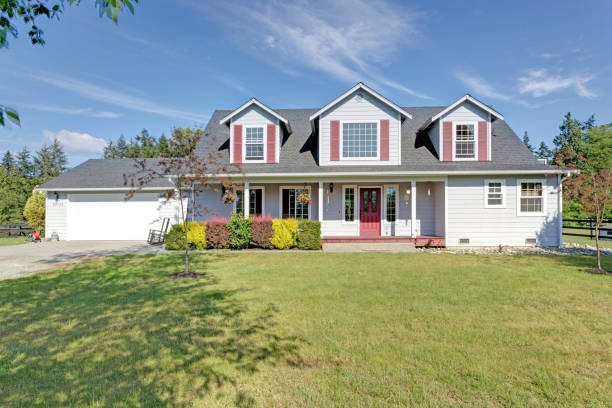 istock Cute home exterior with red shutters on a summer day. 1007485200