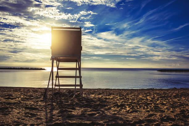 The silhouette of a lifeguard stand as the sun sets over Lake Erie in Presque Isle, Pennsylvania, USA.